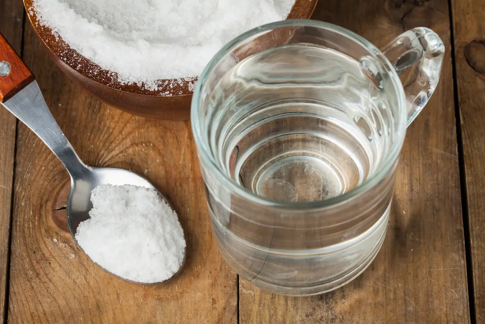 Patient performing gentle salt water rinse as part of extraction site care